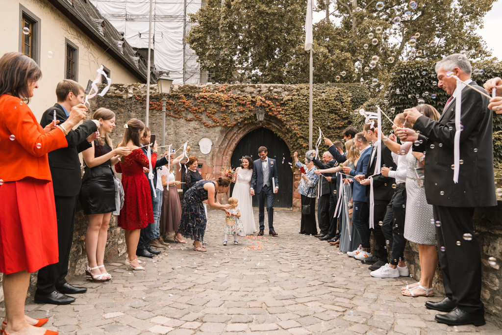 Hochzeitsfotografin Mainz - Brautpaar wird draußen von der Hochzeitsgesellschaft freudig empfangen.